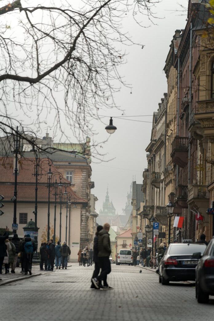 A bustling street scene in historic Kraków with people and traditional architecture.