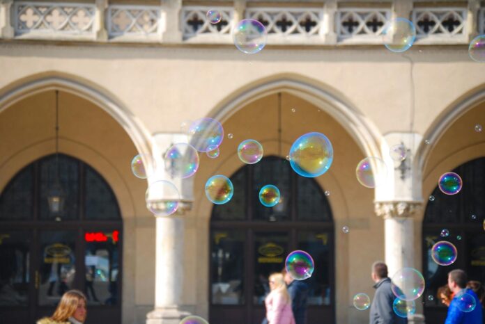 Vibrant soap bubbles floating in front of historic arches in Kraków, creating a playful atmosphere.